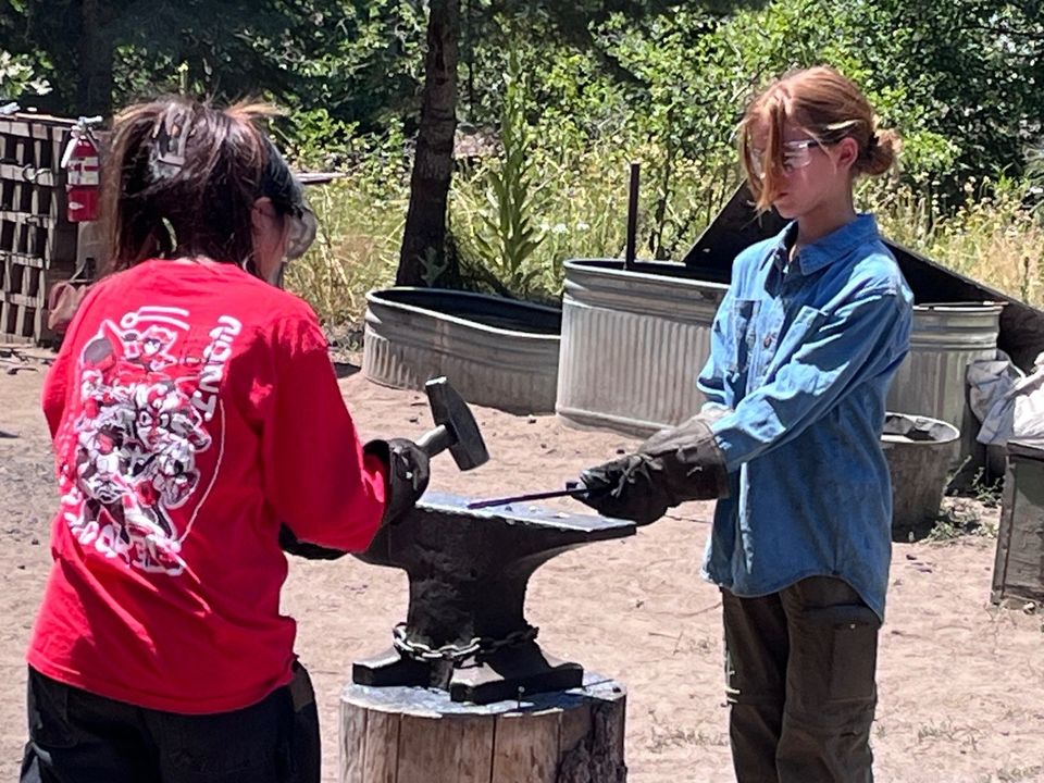 Working the anvil at the camp blacksmith shop